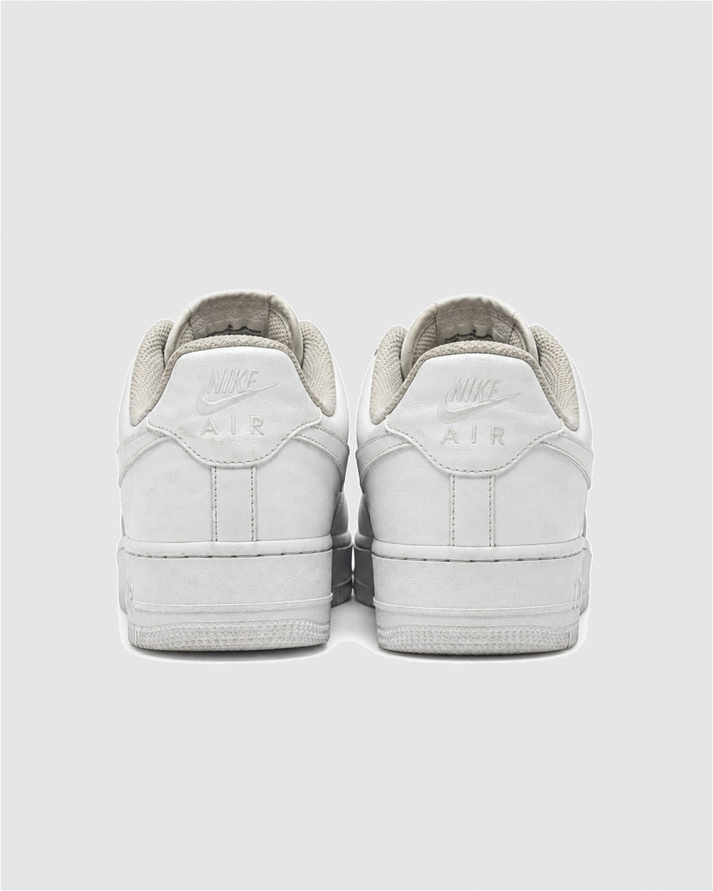 The heels of a pair of Triple White Nike Air Force 1s